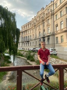 Arne Jeleč sitzend auf einem Brückengeländer in Sarajevo