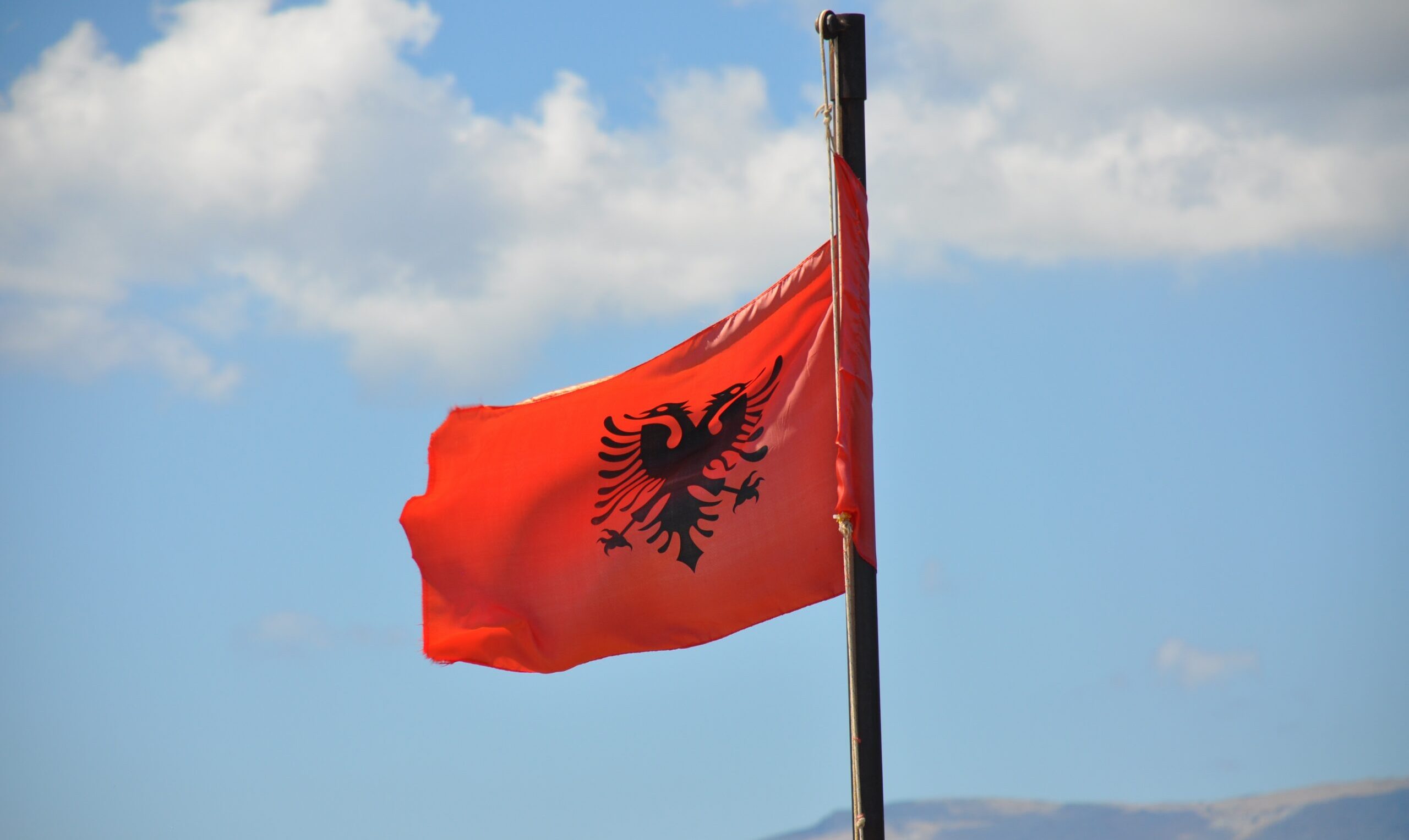 Die albanische Flagge vor dem blauen Himmel